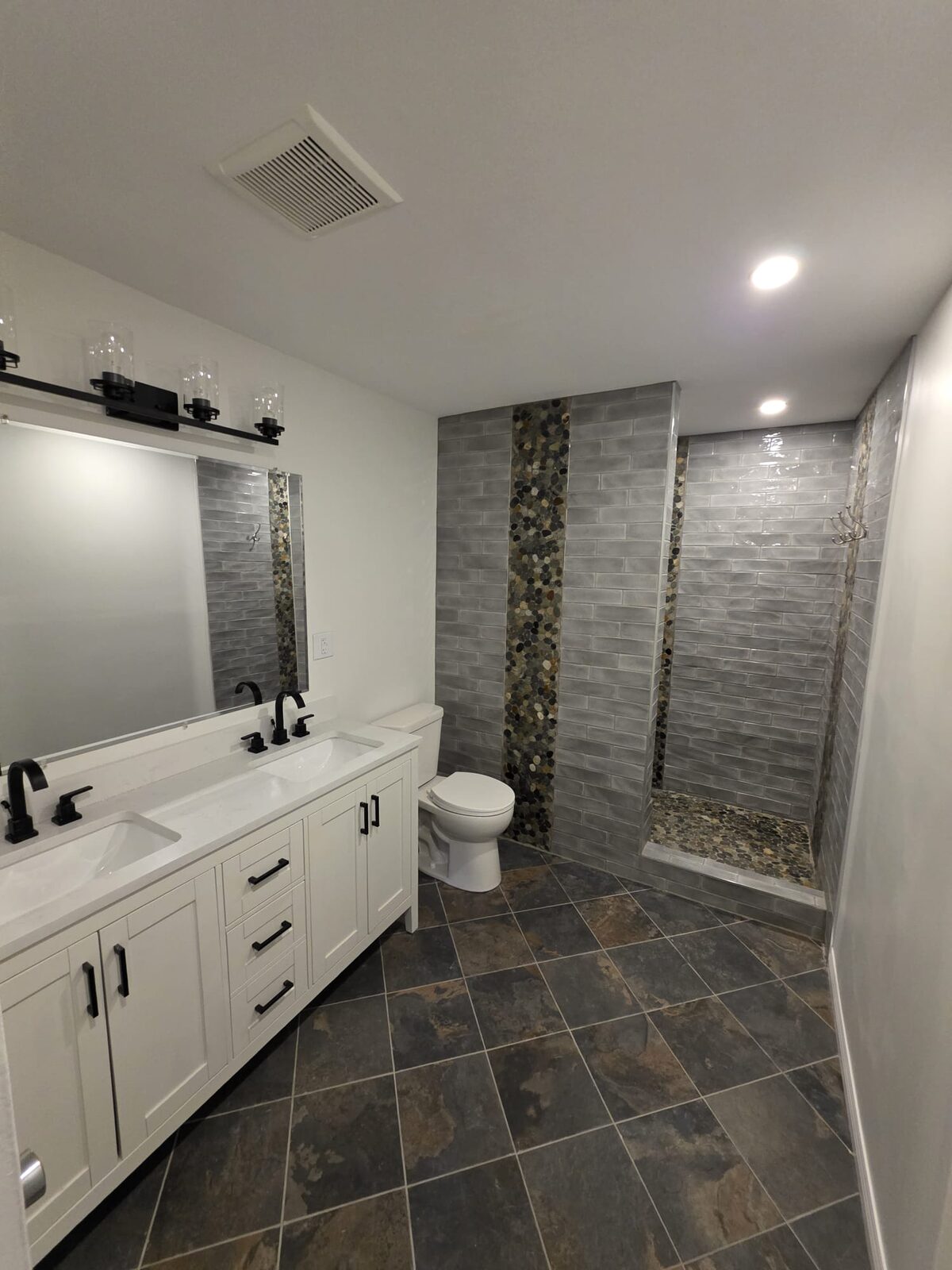 Basement bathroom after ProCoat repaint — pebble shower